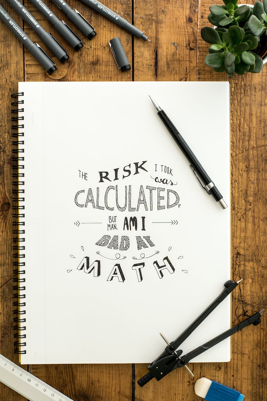 flat lay photography of notebook pen and drafting compass